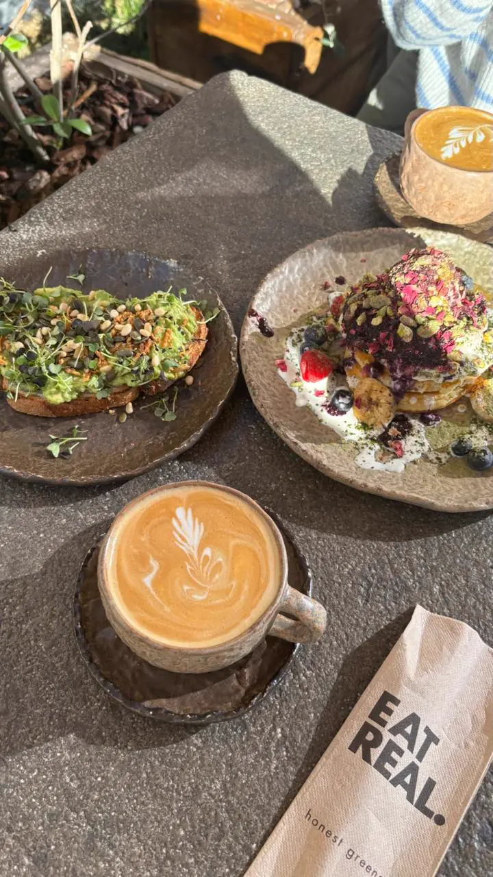 Brunch con tostadas, pancakes y cafés con latte art