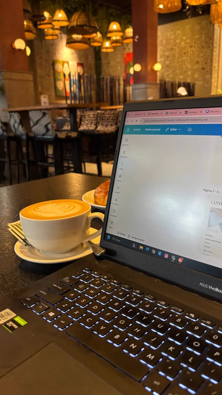Notebook y café con latte art en un café de viaje