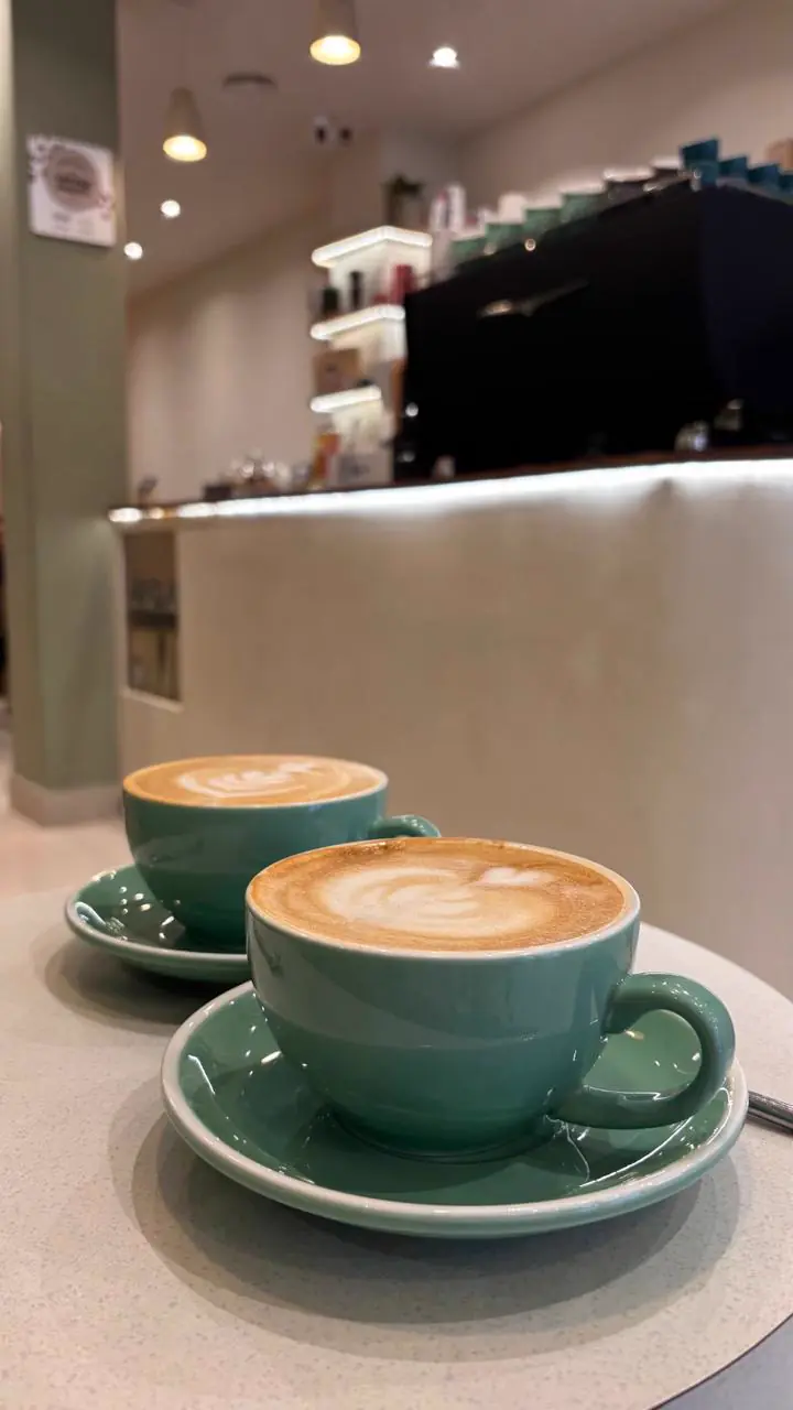 Dos cafés con latte art sobre la barra de un café